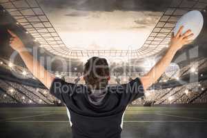 Composite image of back turned rugby player gesturing victory