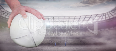 Composite image of a rugby player posing a rugby ball