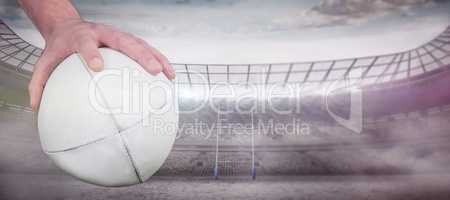 Composite image of a rugby player posing a rugby ball