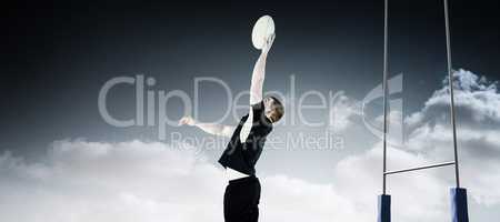 Composite image of rugby player catching a rugby ball