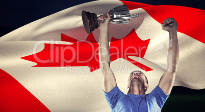 Composite image of happy rugby player holding trophy