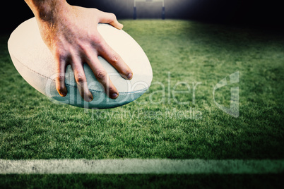 Composite image of rugby player posing feet on the ball