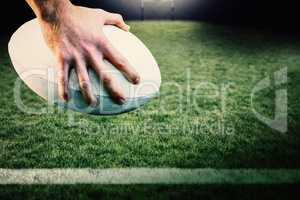 Composite image of rugby player posing feet on the ball