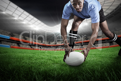 Composite image of portrait of sportsman bending and holding bal