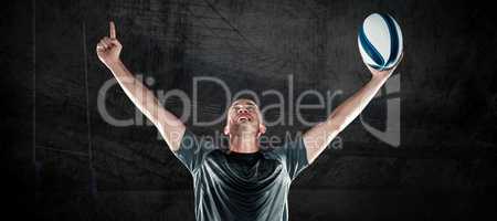 Composite image of successful rugby player holding ball with arm