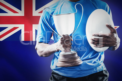 Composite image of mid section of sportsman holding trophy and r