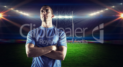 Composite image of confident rugby player looking away with arms