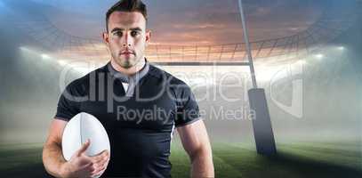 Composite image of tough rugby player holding ball