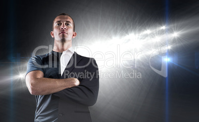 Composite image of confident rugby player with arms crossed