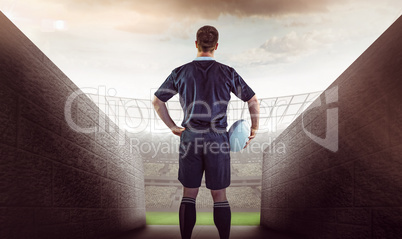 Composite image of rugby player holding a rugby ball