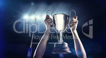 Composite image of successful rugby player holding trophy