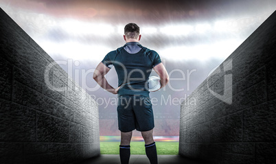 Composite image of rugby player holding the ball