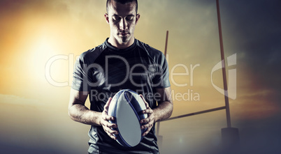 Composite image of thoughtful rugby player holding ball