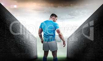 Composite image of rugby player standing with ball