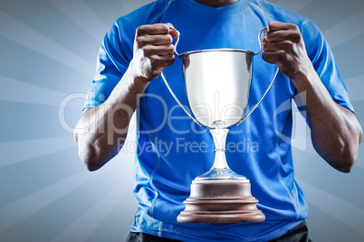 Composite image of mid section of sportsman holding trophy Composite image of mid section of sportsman holding trophy