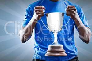 Composite image of mid section of sportsman holding trophy