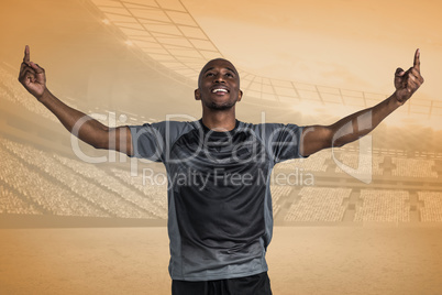 Composite image of happy sportsman with arms raised after victor