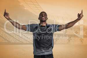 Composite image of happy sportsman with arms raised after victor
