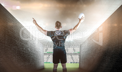 Composite image of rugby player celebrating with the ball