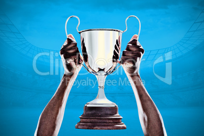 Composite image of cropped hand of athlete holding trophy