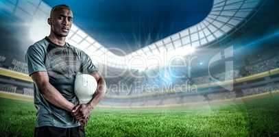 Composite image of portrait of confident sportsman with rugby ball