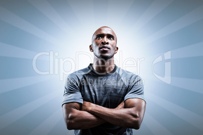 Composite image of thoughtful rugby player with arms crossed