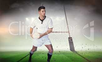 Composite image of rugby player defending with the ball