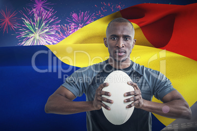 Composite image of portrait of athlete pressing rugby ball