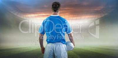 Composite image of rugby player holding a rugby ball