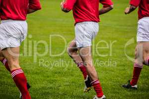 Rugby players jogging on pitch