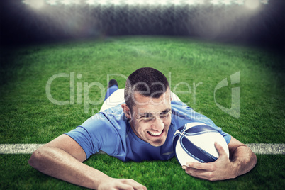 Composite image of confident rugby player lying in front with ba