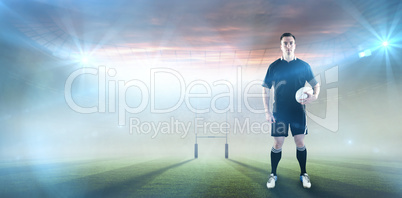 Composite image of rugby player holding a rugby ball