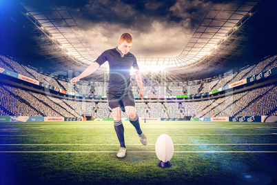 Composite image of rugby player doing a drop kick