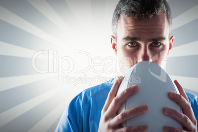 Composite image of rugby player holding a rugby ball