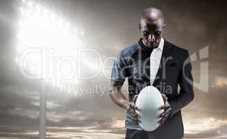 Composite image of thoughtful athlete looking at rugby ball