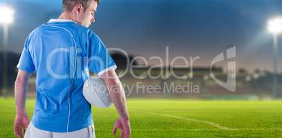 Composite image of rugby player holding a rugby ball