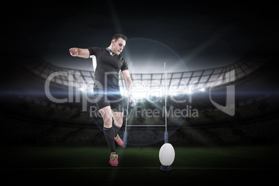Composite image of rugby player kicking the ball