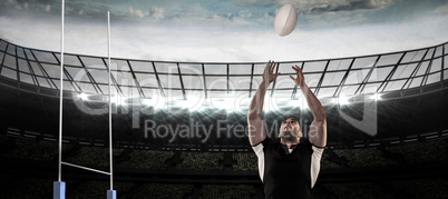 Composite image of rugby player catching the ball