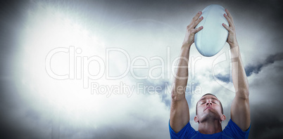 Composite image of rugby player holding ball with eyes closed