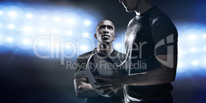 Composite image of calm rugby player thinking while holding ball