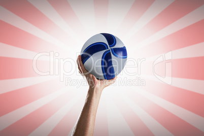 Composite image of rugby player with arm raised holding ball