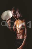 Concentrated shirtless athlete holding rugby ball