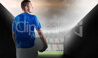 Composite image of rugby player looking away while holding ball