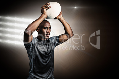 Composite image of confident sportsman throwing rugby ball