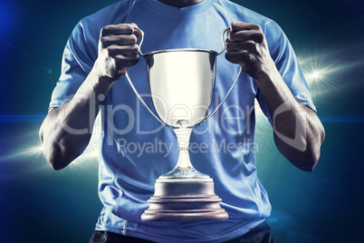 Composite image of mid section of sportsman holding trophy Composite image of mid section of sportsman holding trophy