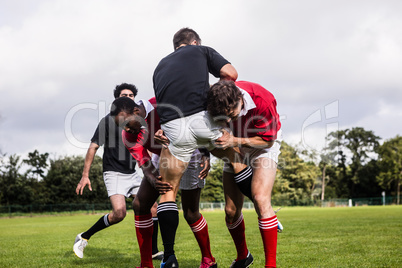 Rugby players tackling during game