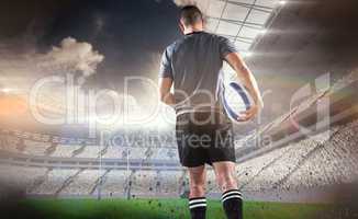 Composite image of rear view of rugby player running with ball