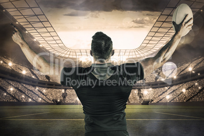 Composite image of rugby player celebrating with the ball