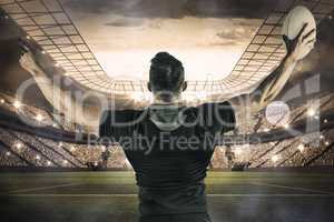 Composite image of rugby player celebrating with the ball