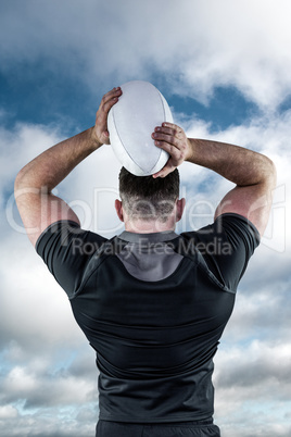 Composite image of tough rugby player throwing ball